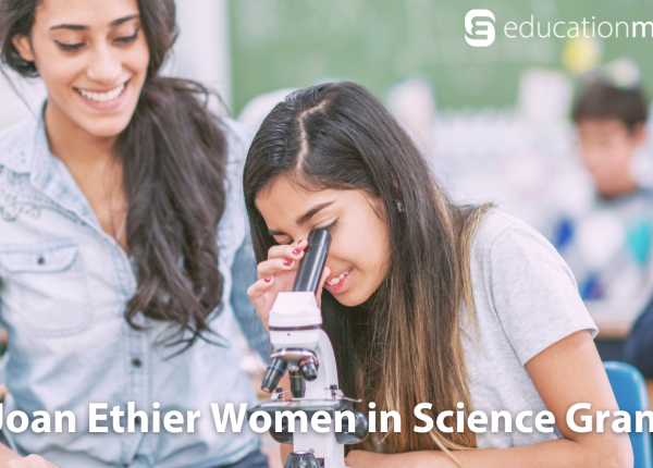 Young girl looks into microscope next to hear teacher - Joan Ethier Women in Science Grant