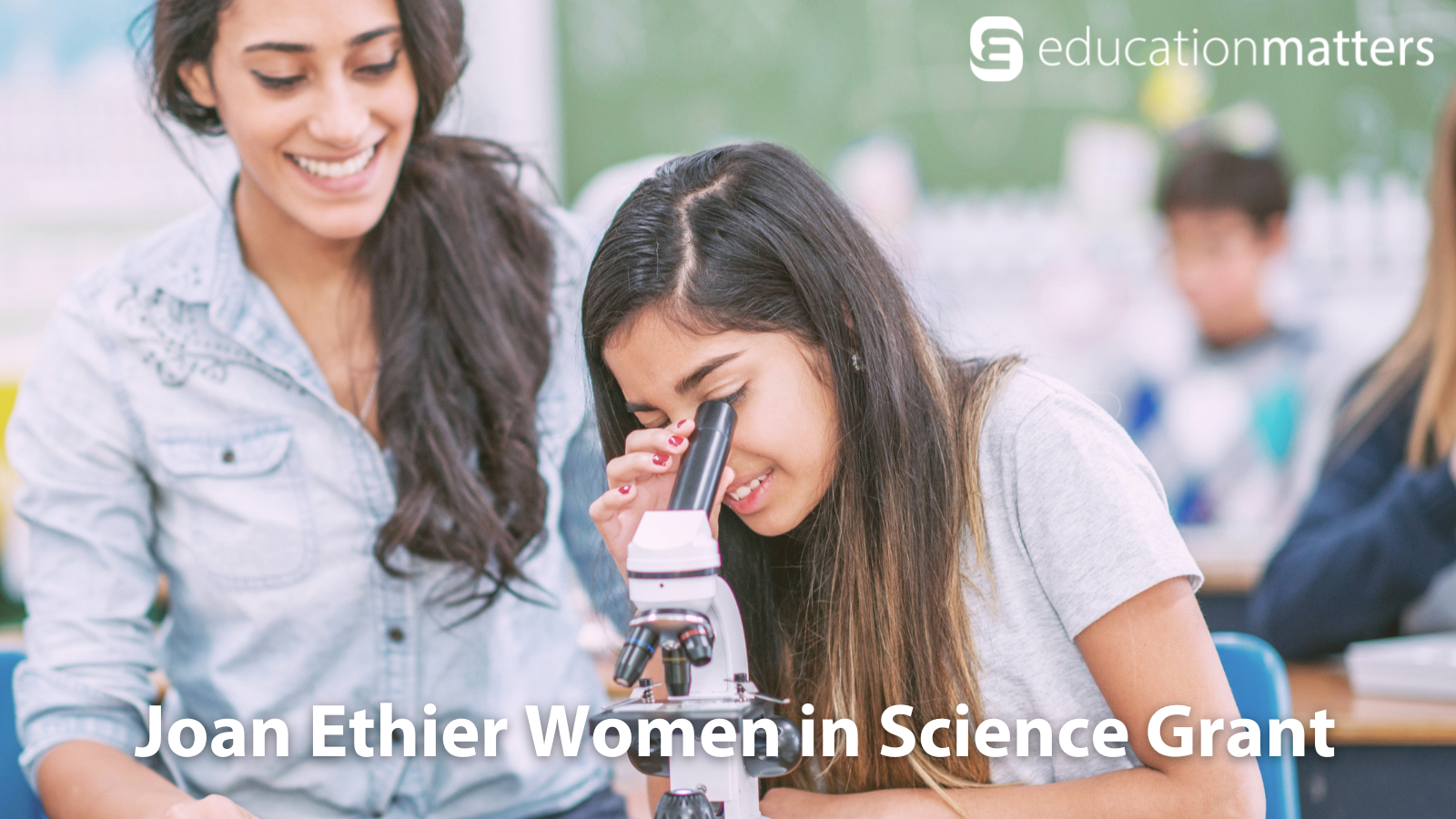 Young girl looks into microscope next to hear teacher - Joan Ethier Women in Science Grant